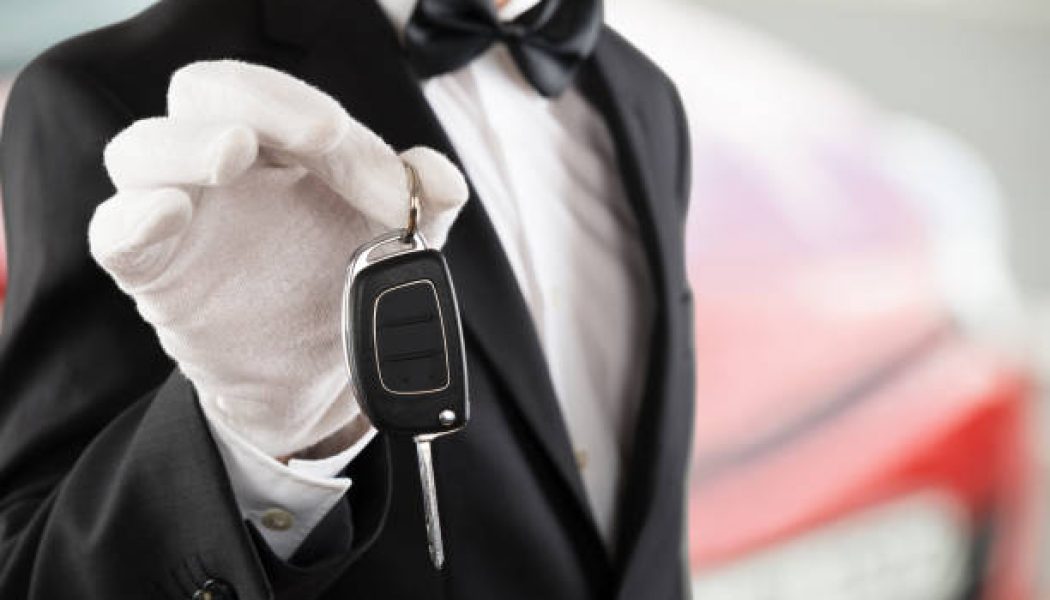 Close-up Of A Valet Boy Holding A Car Key Outside The Car